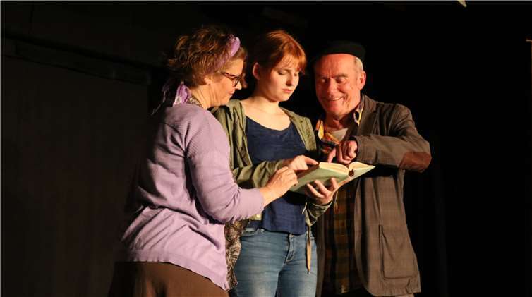 Elinor, Meggie und Mo werfengemeinsam einen Blick in „Tintenherz“.