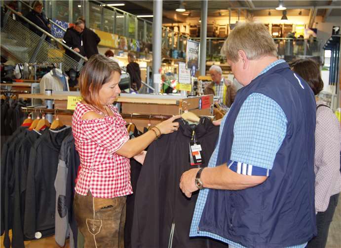 Elisabeth Berger zeigt einem Kunden die neue Winterkollektion.