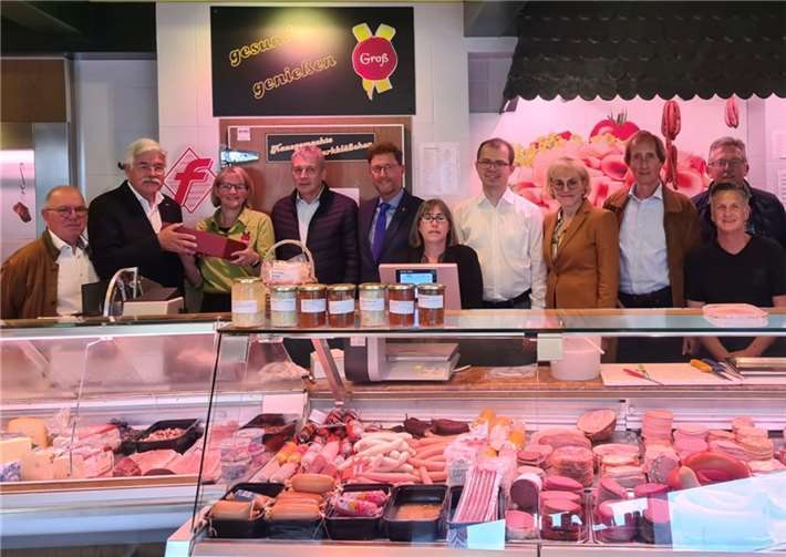 Elmar Lersch (2 v. l.) überreicht Dagmar Groß-Mauer (3.v. l.) ein Weinpräsent. Detlef Odenkirchen (Bildmitte) und die Mitglieder des MIT Kreisverband Ahrweiler freuen sich über die hervorragende Auslage des Warenangebots