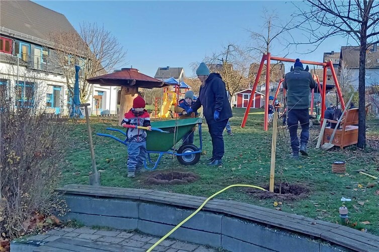 Eltern, Erzieher, Hausmeister und Kita-Kinder beteiligten sich gemeinsam an der Pflanzaktion in der Kita St. Martin in Ochtendung. Auf den Freiflächen entstanden Spiel- und Schattengebüsche, ergänzt durch eine Sonnen- und Sichtschutzhecke sowie einen gespendeten Apfelbaum.