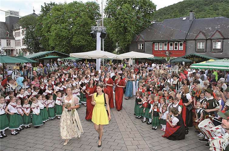 Empfang der Weinmajestäten im Weindorf. Bürgerwehr und Tanzgruppen stehen beim Einmarsch Spalier.