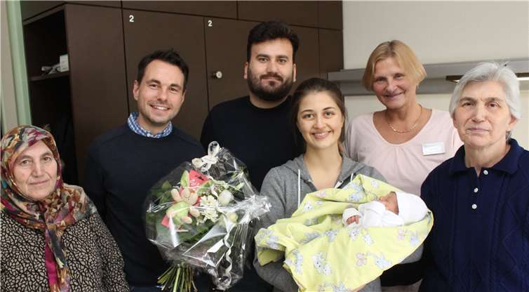 Enes Uzun im Arm seiner Mutter Hülya, eingerahmt von seiner Urgroßmutter und Großmutter sowie von Oberbürgermeister Langner (2. v.l.), seinem Vater Emrah und Hebamme Stani Faber (2. v.r.).Privat