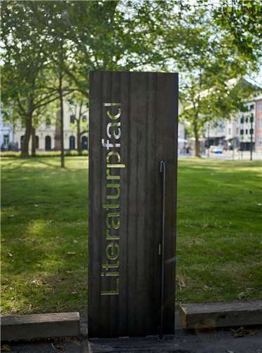 Entlang zweier Längswege stehen nun acht Stelen aus Cortenstahl, welche an ein Lesepult erinnern und mit Textfolien versehen sind. Bei den Inhalten der Folien handelt es sich um Literaturauszüge und Textanreißer, welche zum Weiterlesen anregen sollen.