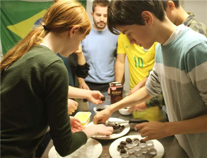 Erasmus-Studierende bereiten gemeinsam mit den Schülerinnen und Schülern des Franziskus Gymnasiums Nonnenwerth die brasilianische Süßspeise „Brigadeiro“ vor.Foto: RheinAhrCampus