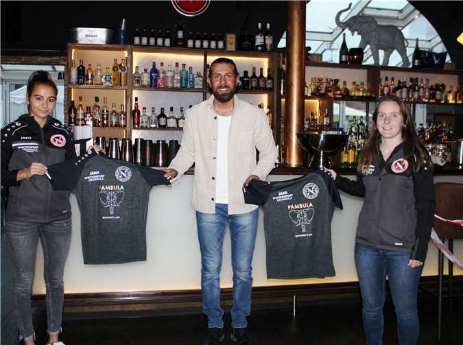 Erneut unterstützt Adem Celik, der hier mit den Spielerinnen Léa Daiz (l.) und Stefanie Lotzien (r.), die neuen Aufwärmshirts präsentiert, den SC 13 Bad Neuenahr.Foto: privat