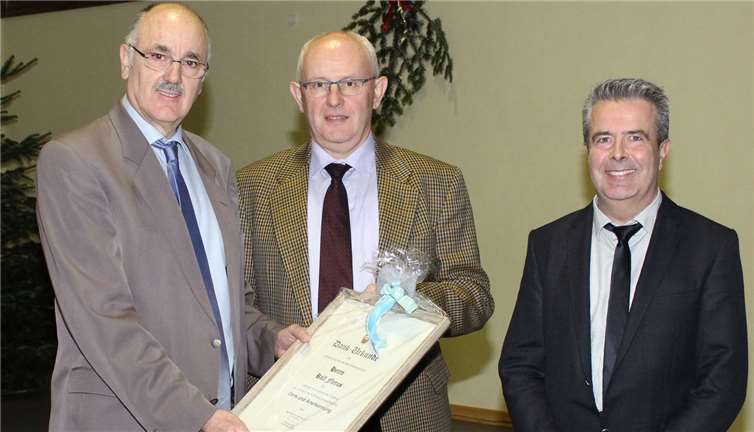 Erster Beigeordneter Hans-Josef Marx (links) händigt Rolf Flerus im Beisein seines Nach¬folgers Bernd Lieschwé eine Dankurkunde aus.