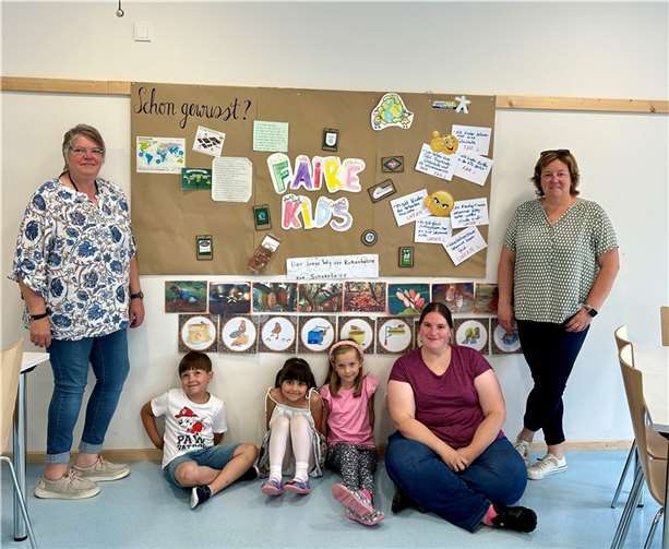 Erzieherinnen und einige Kinder vor einer gestalteten Wand zum Thema „Fair“.  Foto: Christiane Müller-Grün/ Stadt Mayen