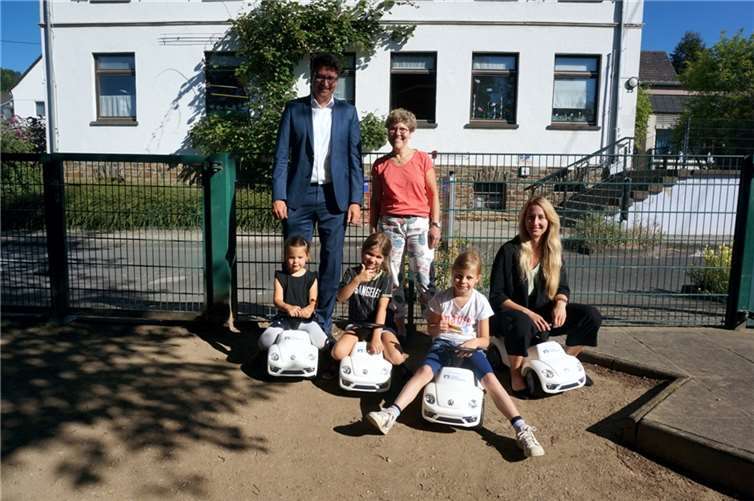 Esther Tumenas (rechts) und Christian Kehr (links), Bereichsleiter Regionalmarkt Rhein der VR Bank bei der Übergabe der BobbyCars an die ev. Kita Feldkirchen. Foto: privat
