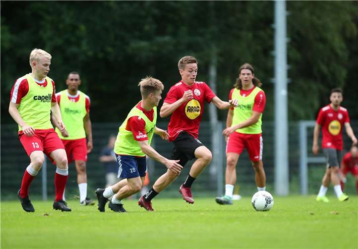 Etablierte Rot-Weiß-Kräfte wie Marcus Fritsch (li.), Alexis Weidenbach und Thilo Kraemer (im Hintergrund), Neuzugänge wie Moritz Hannappel (rotes Trikot) und Probespieler wie Florian Oloff (vorne) standen am Mittwochabend beim Trainingsauftakt von Rot-Weiß Koblenz auf dem Platz.Foto: TH