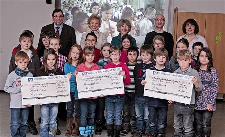 Etliche Kinder der dritten und vierten Klassen mit den Schecks für: Bernd Schiffarth, Marita Falk-Solheid, Jutta Ihmig, Schulelternbeirat Benjamin Bratke und stellvertretende Rektorin Angelika Schifferings.SES