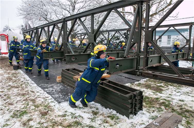 Behelfsbrücke in Heimerzheim mit vereinten Kräften an ihren Platz geschoben Etwa 60 ehrenamtliche Helfer des THW schoben am Samstag die Behelfsbrücke in der Heimerzheimer Quellenstraße über die Swist.