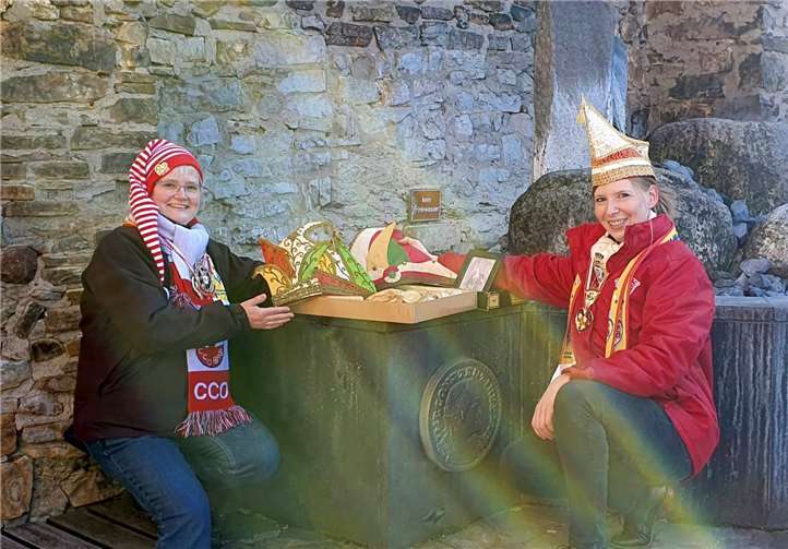 Eva Bonn (links) und Anna Sauer (rechts) trafen sich am Hexenturm auf dem Salhofplatz unterhalb des Wehrgangs, damit die beiden historischen Präsidentenkappen coronakonform an das CCO-Fastnachtsmuseum bei strahlendem Sonnenschein überreicht werden konnten. Ab Mai, wenn alles klappt, werden die beiden närrischen Kopfbedeckungen dann im Fastnachtsmuseum im Martinsschloss zu bewundern sein. Foto: CCO