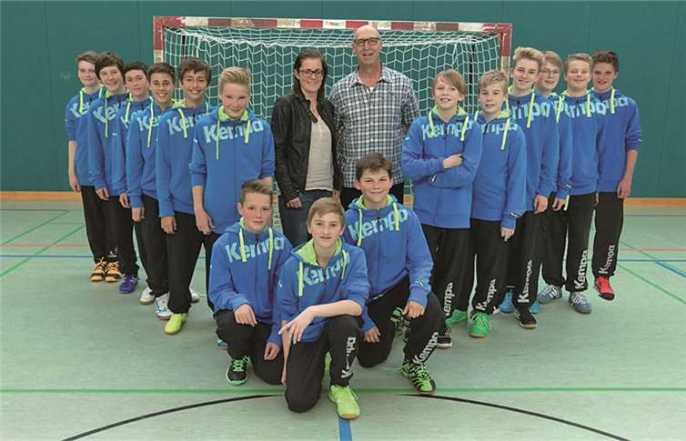 Eva Geisen-Schlich von Herren- und Sportmode Mintgen übergibt die neuen Kempa-Anzüge. Die Spieler, von links: Hagen Krempel, Peter Stein, Enrico Ediger, Marvin Steuernagel, Giuliano Gonschorek, Matthis Röser, Louis Hürter, Paul Frey, Bjarne König, Paul Kummetz, Felix Effert, Marcel Gundlach, Steven Timaschov, Leo Neufingerl und Moritz Eis. privat