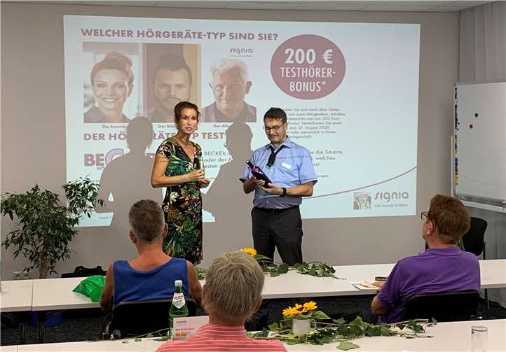 Eva Keil-Becker, Geschäftsführerin BECKER Hörakustik, dankt Thomas Ehlers für den interessanten Vortrag mit einem Koblenzer Weinpräsent.Quelle: BECKER Hörakustik