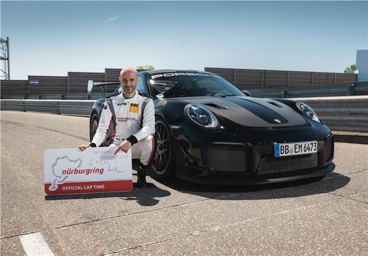 Fahrer Lars Kern mit dem offiziellen Rekordschild auf dem die Zeit notiert ist: Am Ende der Nordschleifen-Runde stoppte die Uhr bei 6:43,300 inuten.Foto: Porsche AG