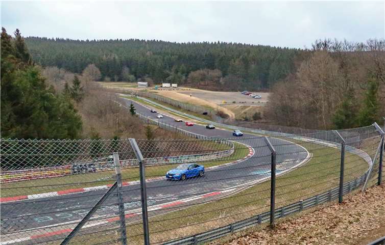 Fahrzeuge auf der Strecke, der angrenzende Parkplatz menschenleer. Das berühmte „Brünnchen“ ist sonst ein Besucher-Hotspot an Karfreitag. Foto: Nürburgring