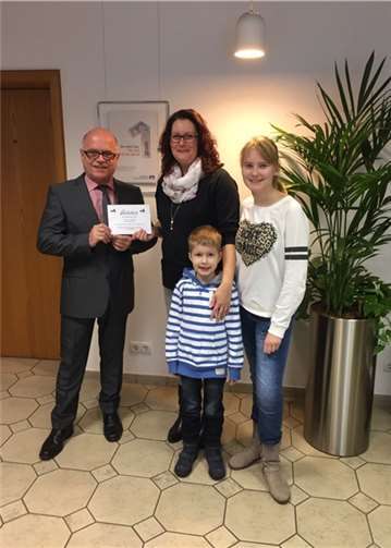 Familie Wendling gewinnt das Multi-Kanal-Gewinnspiel der Volksbank RheinAhrEifel und nimmt von Privatkundenberater Berthold Leinz ihren Preis, einen 2.500 Euro-Reisegutschein, entgegen.  Privat