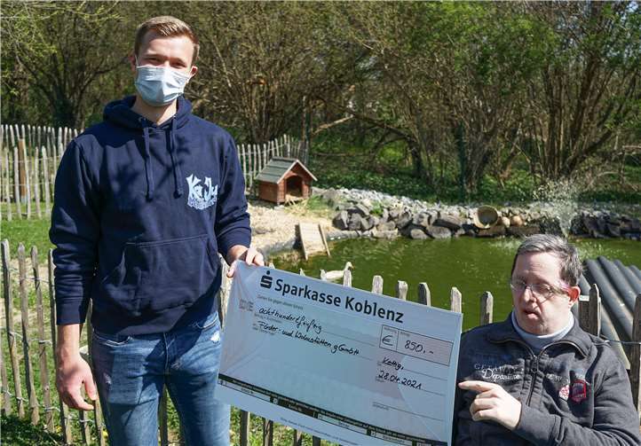 Felix Becker, Kath. Jugend Mülheim, überreicht den Scheck an den Beschäftigten der Tagesförderstätte Rainer Michalik. Foto: privat