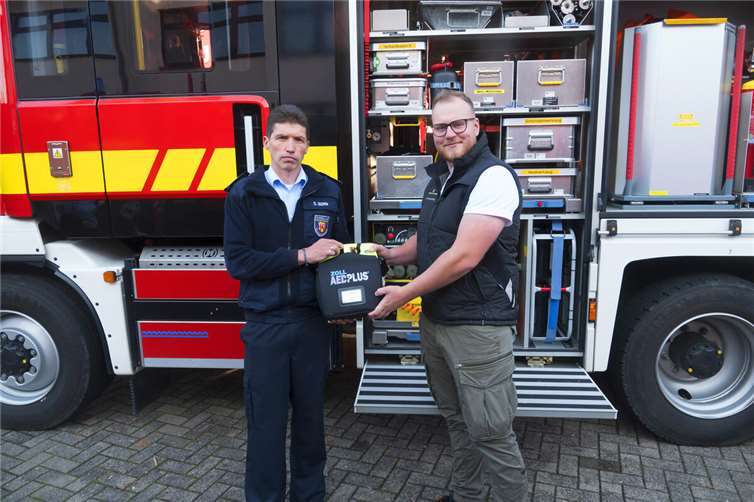 Felix Lichtenthäler (rechts) übergibt den Defibrillator an Wehrführer Sven Born.