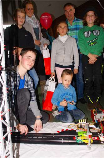 Ferdinand Krämer (vorn links) war als Gewinner des Landeswettbewerbs „Jugend forscht 2018“ am Stand des VDI Mittelrhein und begeisterte Groß und Klein mit seiner Carrerabahn, auf der die Besucher als „Mensch gegen Computer“ beim Autorennen um den Sieg kämpften.VDI