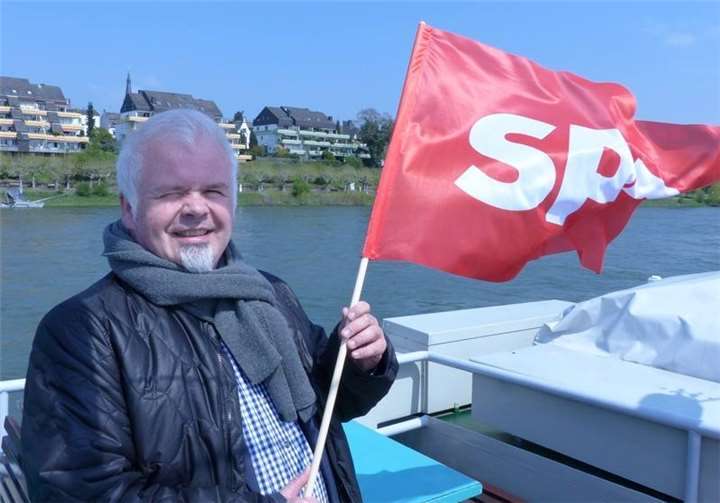 Ferhat Cato auf dem Schiff der IG Metall auf dem Weg nach Koblenz zur Kundgebung der Gewerkschaft, mit roter SPD-Fahne und seinem Heimatort Engers im Hintergrund.privat