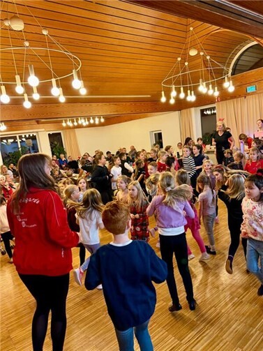Festliche Tänze und freudige Gesichter in weihnachtlichem Ambiente.