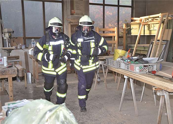 Feuerwehrkameraden auf der Suche nach Verletzten in der Schreinerei.