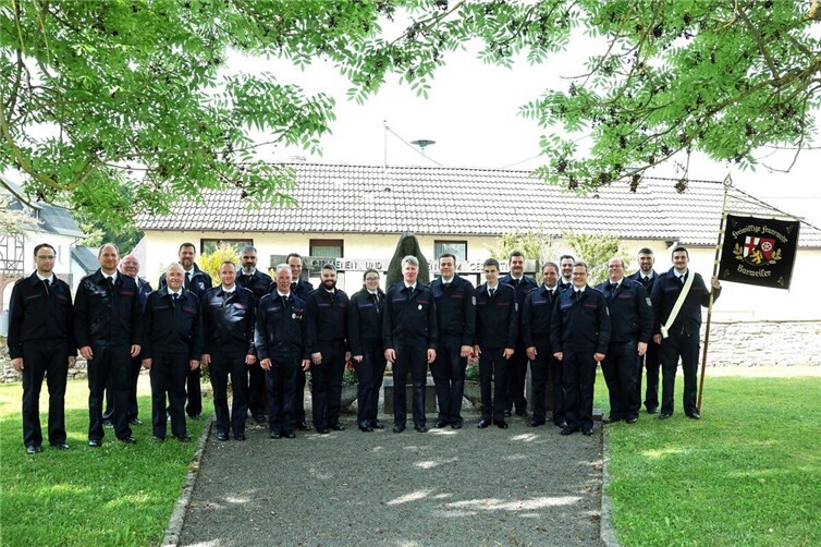 Feuerwehrleute am Ehrenmal an der Kirche