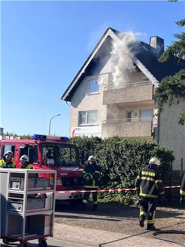 Feuerwehrleute bewältigen einen simulierten Wohnhausbrand mit Rauchentwicklung zur realistischen Vorbereitung.