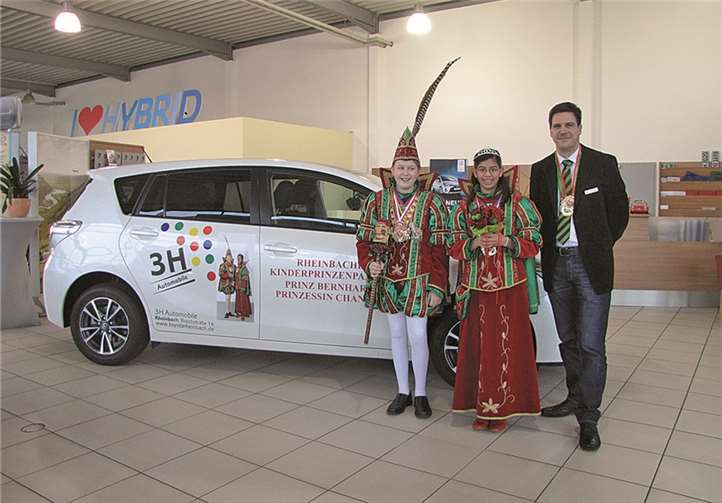 Filialleiter Gunnar Brunke und das Kinderprinzenpaar vor dem Prinzenfahrzeug. privat