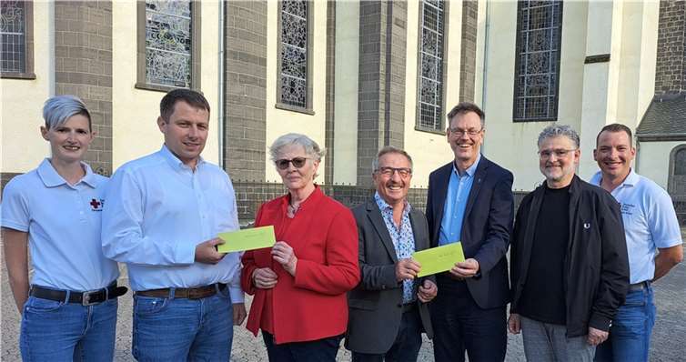 First Responderin Jenny Schneichel, DRK Vorsitzender Georg Stein, Irmgard und Rudolf Schneichel, Pfarrer Norbert Missong, Pfarrgemeinderatsvorsitzender Wolfgang Weber und First Responder Matthias Schneichel vor der Sankt Dionysius Pfarrkirche. Foto: Hildegard Reis