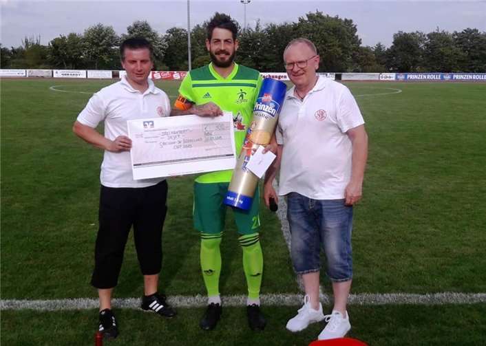 Florian Schlich, Kapitän der SG Eintracht Mendig/Bell, nahm aus der Hand von Marcus Reiter (Geschäftsführer der Abteilung Fußball, links) und von Frank Breitbach (Vorsitzender des Gesamtvereins, rechts) den Scheck über 300 Euro und eine Riesen-Prinzenrolle entgegen.Fotos: SK/Strolch-Foto
