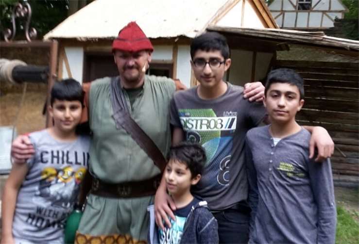 Flüchtlingskinder mit einem Akteur des Stücks "Robin Hood".