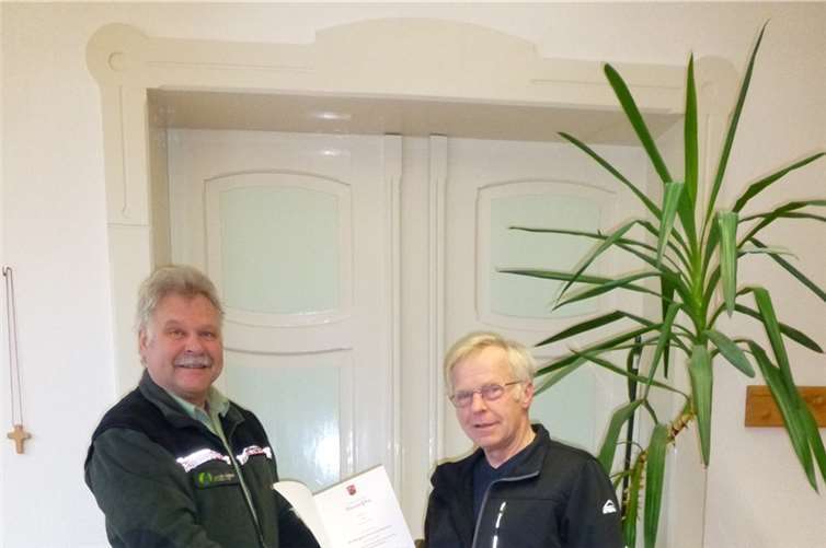 Forstdirektor Winand Schmitz (l.) überreicht die Dankesurkunde der Ministerpräsidentin Malu Dreyer für 40-jährige treue Dienste an Forstwirt Franz-Josef BaurFrank Hüllen/Landesforsten RLP