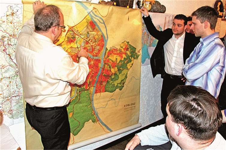 Frank Hastenteufel, Leiter des Amts für Stadtentwicklung und Bauordnung der Stadt Koblenz (l.), erläutert dem JU-Kreisvorsitzenden Torsten Welling (2.v.r.) und den Anwesenden die Besonderheiten der verschiedenen Pläne.