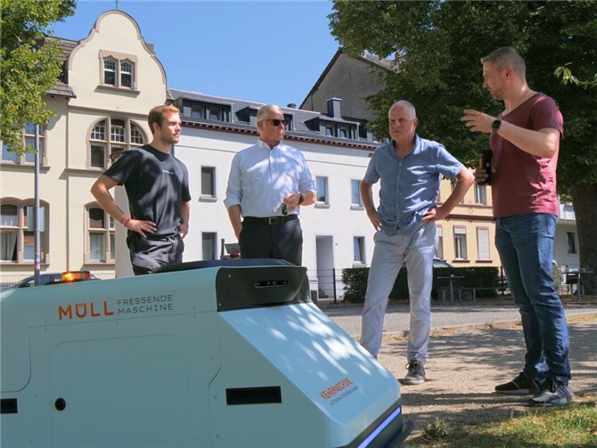 Frank Schneider (2. von links) und Thomas Riehl (3. v. l.) sind überzeugt: Der Müllsauger-Roboter ist für die SBN eine sinnvolle Investition. Acht Stunden kann er mit einer Akkuladung arbeiten, erläutern die Mitarbeiter des Startup-Unternehmens Angsa Robotics.Foto: SBN/Maxie Meier 