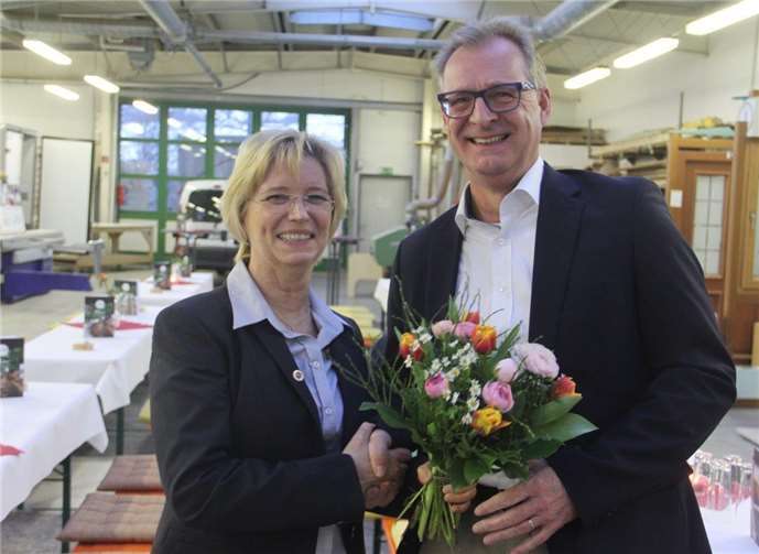 Frank Zender überreicht der Gastgeberin Frau Volk einen Strauß Blumen.