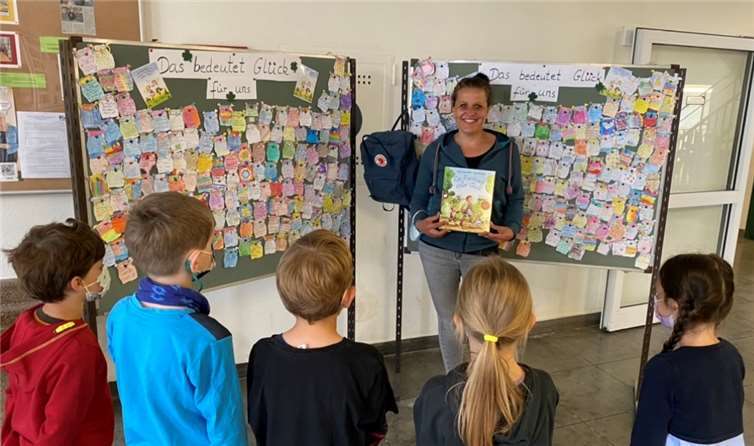 Frau Naujoks präsentiert einigen Kindern das Buch „Ein Rucksack voller Glück“. Foto: privat