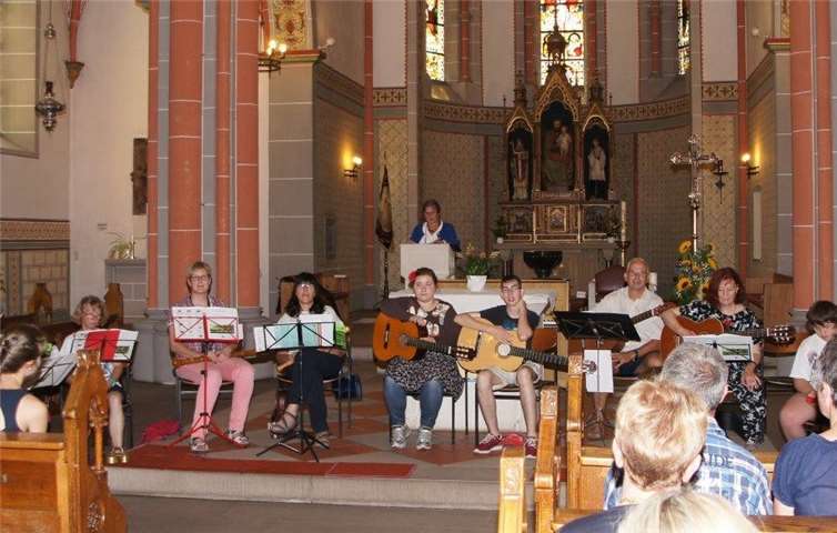 Frau Schürmann(Vorsitzende des Chores) begrüßt die Gäste, im Vordergrund sitzen die Mitglieder des Inklusionsorchesters der Kreismusikschule Mayen-Koblenz unter Leitung von Frau Anneke Bouwman (5. v. links).