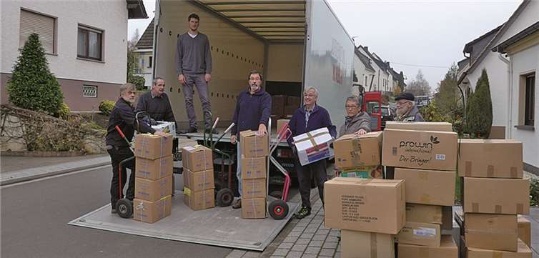 Freiwillige Helfer beluden die LKWs mit den Kisten. privat