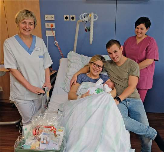 Freude über das erste Baby des neuen Jahres im St. Nikolaus-Stiftshospital Andernach: Familie Hasenstab (auf dem Bett sitzend) erhielt neben herzlichen Glückwünschen von Stationsleitung Ulrike Dungs-Schwertner (li.) und Hebamme Tina Kloos einen Präsentkorb des Hauses, der den Einstieg ins erweiterte Familienleben erleichtert.