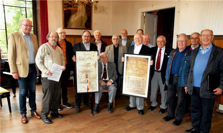 Freude über ein schönes Geschenk: Die Chorgemeinschaft erhielt aus den Händen von Hardy Rehmann (Denkmalverein, links) zwei Faksimile von Dokumenten aus der Historie, stolz gezeigt vom 1. Vorsitzenden der Cäcilia Michael Griehl (Vierter von links) und vom 2. Vorsitzenden Peter Romainczyk. Foto: Denkmalverein