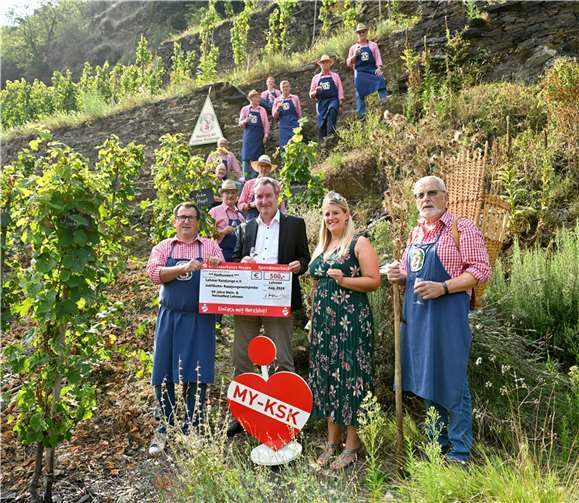 Freuen sich im Weinberg der Lehmer Razejunge über die Spende der KSK Mayen: Vorne v.l.: Oberrazejung Guido Ackermann, KSK-Filialleiter Klaus Wermes, die Lehmener Weinkönigin Jessica I. und Razejung Ralf Menden mit den Razejunge-Kollegen im Hintergrund. Foto: KSK Mayen/ Ralph Künzel