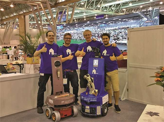 Freuen sich mit Serviceroboter Lisa über den Weltmeistertitel beim internationalen RoboCup-Wettbewerb im chinesischen Hefei: (v.l.) Das Koblenzer Team mit den Studenten Florian Polster, Raphael Memmesheimer, Stephan Manthe und Teamleiter Viktor Seib aus der Arbeitsgruppe Aktives Sehen. Universität Koblenz-Landau