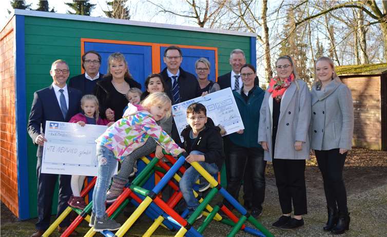 Freuen sich mit den Kita-Kindern über das neue Gartenhäuschen (v.l.): Matthias Herfurth (Vorstand VR-BANK Neuwied-Linz), Thomas Voß (Geschäftsführer HTZ), Klaudia Schneiders (Leiterin Kita Kinderland), Franz-J. Köllner (Geschäftsführer Raiffeisendruckerei), Silke Lutter (Betriebsratsvorsitzende), Günter Visse (Geschäftsbereichsleiter Raiffeisendruckerei), Sandra Schunk (Koordinatorin AFH), Alina Knue und Lara Bender (Auszubildende der VR-BANK).Foto: HTZ