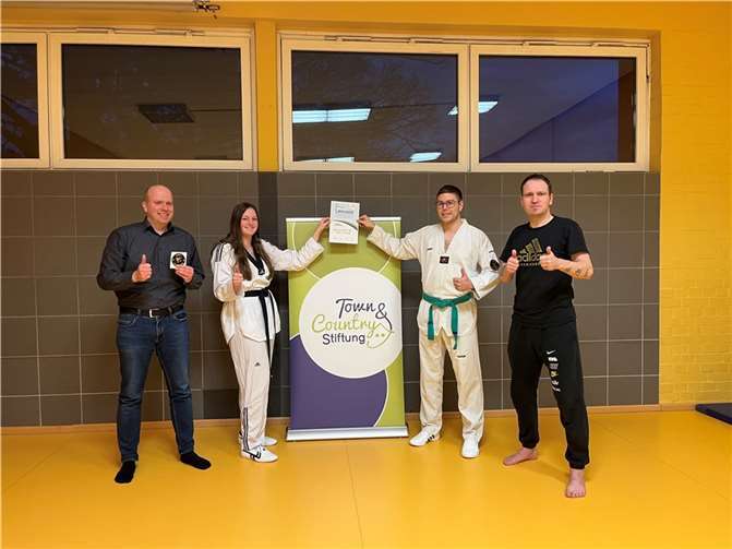 Freuen sich über 1.111 Euro für ihr Engagement: Stiftungsbotschafter Philipp Deutsch übergab die Urkunde an Tamara Hass , 2. Vorsitzende der Abteilung „Manu‘s Taekwondo“ der SG DJK 1909 e. V. Andernach, Fabio Luz (1. Vorsitzender) und Manuel Meier (Cheftrainer) (v. l. n. r.). Foto: AN Massivhaus GmbH