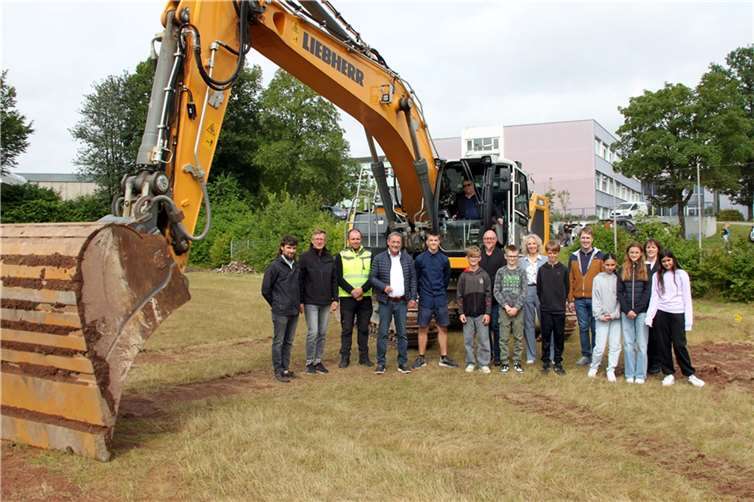 Freuen sich über den ersten Erdaushub durch Schulleiter Ernst-G. Carstensen. (v.l.n.r.): Simon Böhler, Architekt, Roman Kämpf, Kreisverwaltung, Matthias Lahr, Tiefbauunternehmen, Landrat Achim Schwickert, Dominik Mondorf, Schülersprecher, Horst Engel, Personalratsvorsitzender, und von der Schulleitung Charlotte Müller, Thomas Eberth und Heike Ruhland sowie die Klassensprecher der 5. und 6. Klassen.  Foto: Kreisverwaltung / Carolin Faller