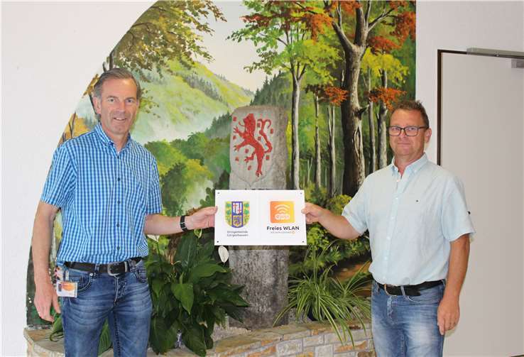 Freuen sich über den neuen WLAN-Punkt in Görgeshausen (v.l.n.r.): Bürgermeister Jürgen Kindler und evm-Kommunalbetreuer Norbert Rausch bei der Übergabe der Hinweistafel am Löwenstein. Foto: evm