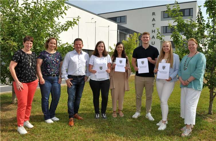 Freuen sich vor dem Rathaus über den erfolgreichen Abschluss, von links: Britta Röhrig, Silke Grohs, Bürgermeister Holger Jung, Milena Grzesik, Bercem Akter, Jannik Zirbes, Lisa Schmucker und Christine Hilger. Quelle: Stadt Meckenheim