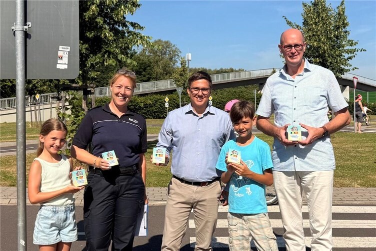 Freuten sich über die Unterstützung für den Jugendverkehrsübungsplatz in Rheinbrohl: Filialleiter Marc Opper (mitte), Verkehrssicherheitsberaterin Nadine Prien (2. v.l.) und Bürgermeister Jan Ermtraud (rechts) bei der Übergabe der Markierungskreiden. Foto: VG Bad Hönningen